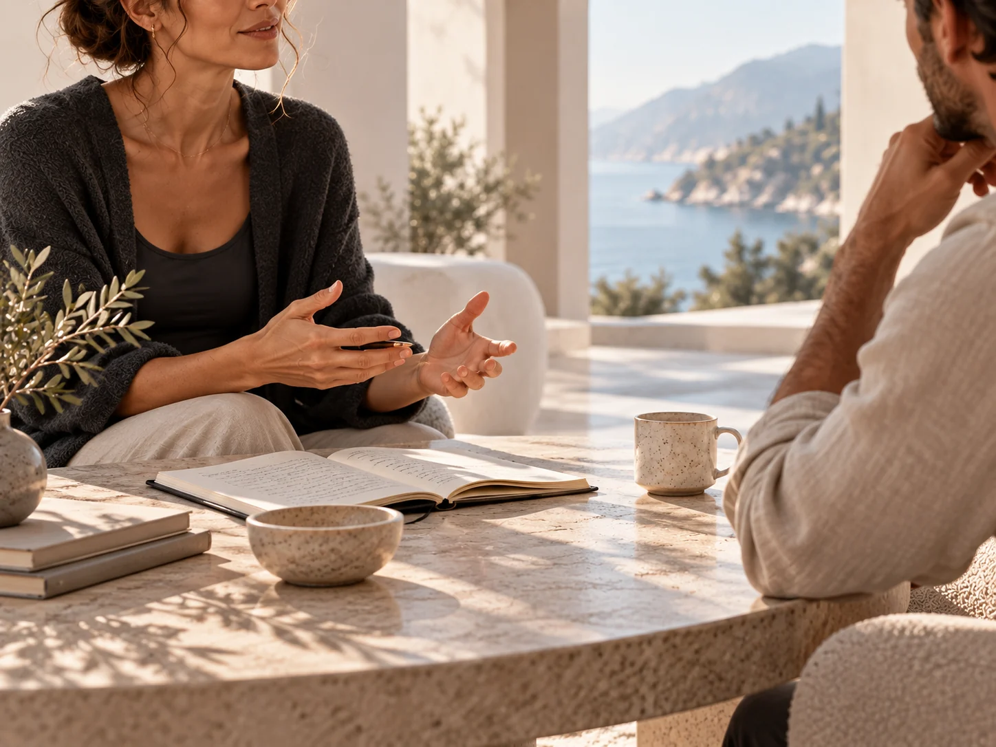 Close view of a coaching conversation, hands gesturing above an open notebook